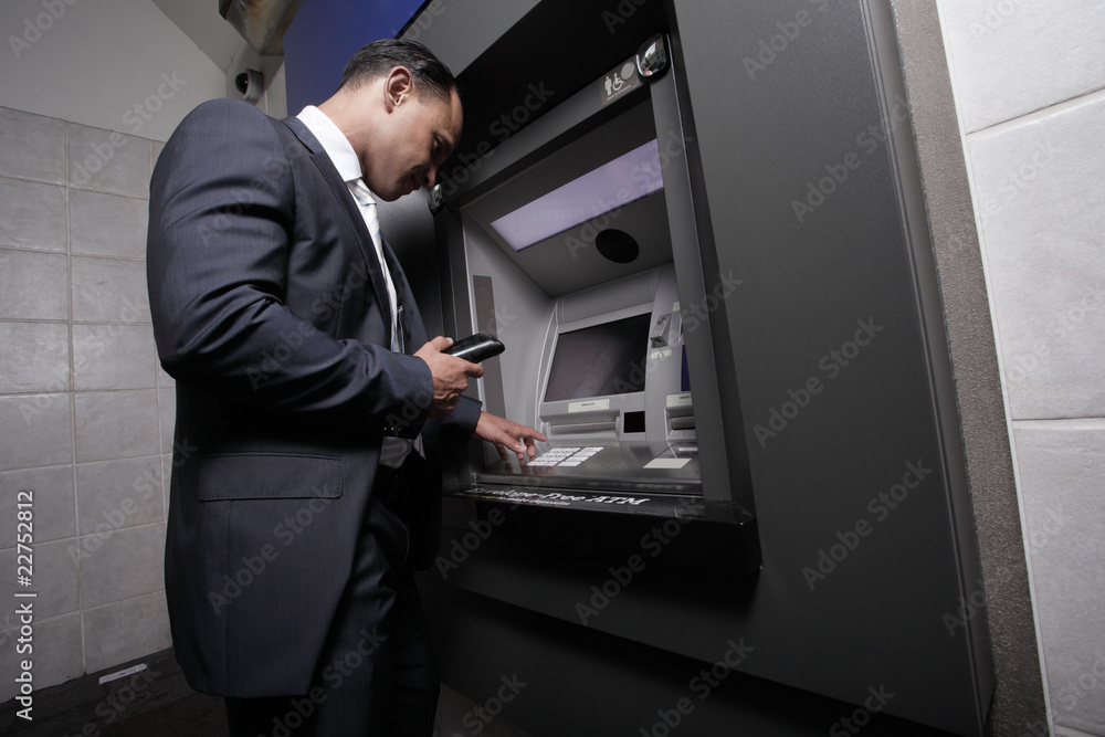 Businessman at an atm machine Businessman at an atm machine