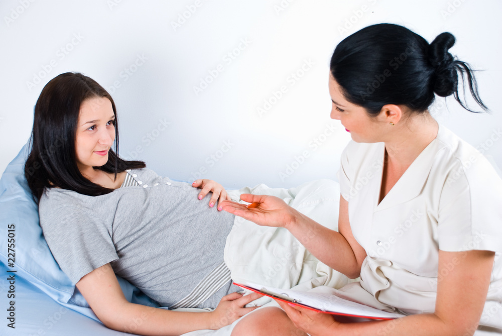 Doctor giving explanations to a pregnant Doctor giving explanations to a pregnant