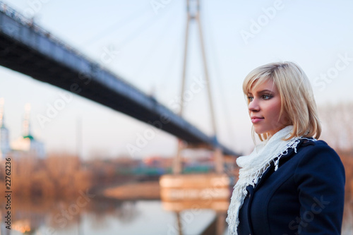 Young woman against a bridge.