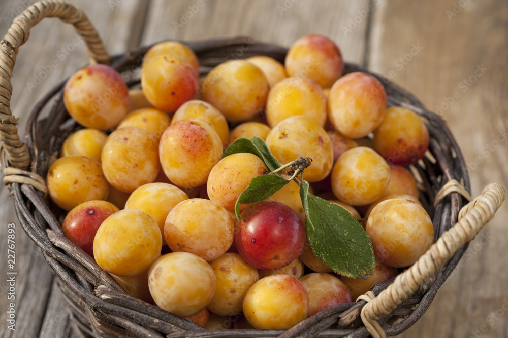 Basket full of fresh yellow plums