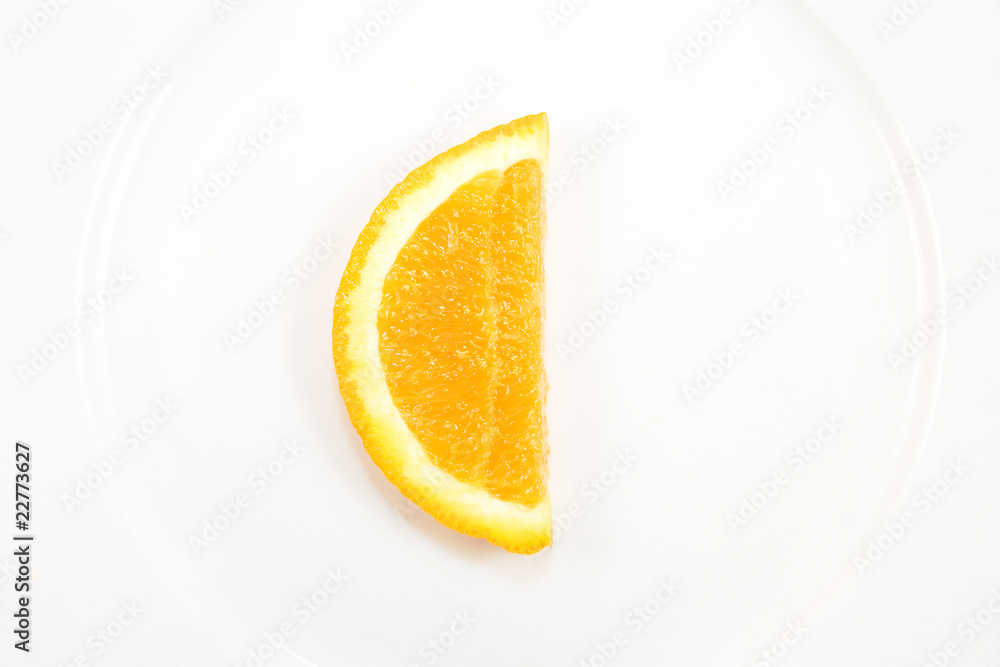 Orange slice, C shape symbolizing vitamin C, on white plate