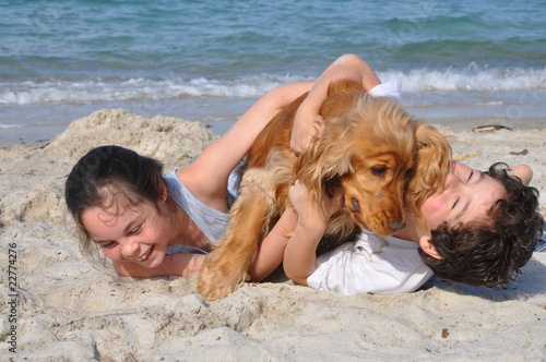 2 enfants et leur chien heureux sur la plage