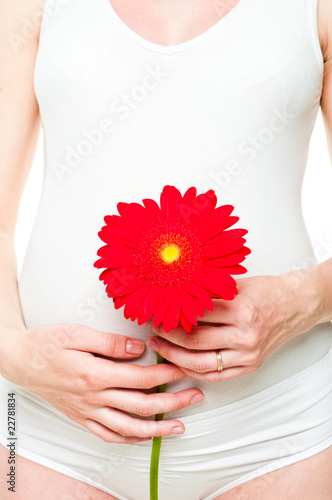 closeup of a young pregnant woman with red flower