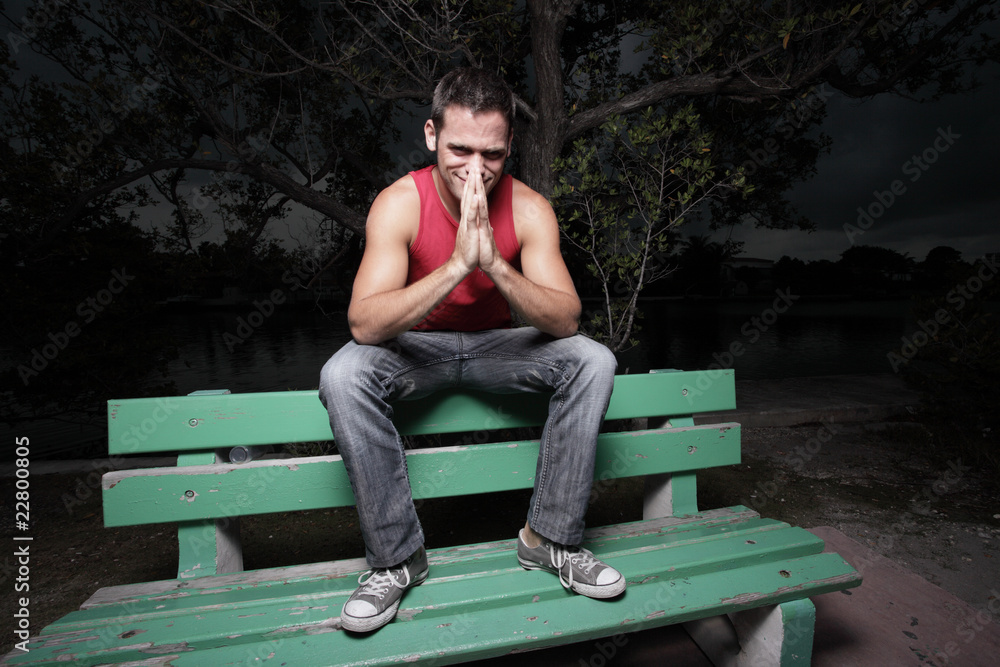 Man sitting on a bench at night Man sitting on a bench at night