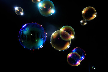 Soap bubbles on black background .