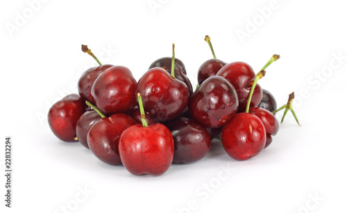 A group of several fresh cherries