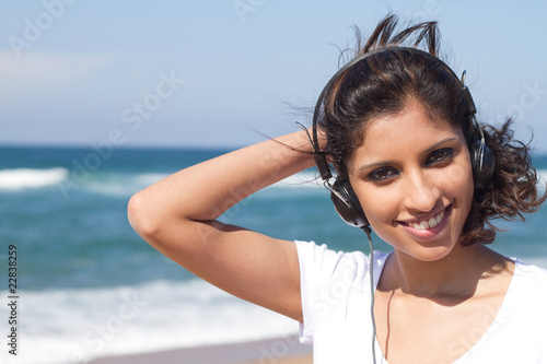 indian woman listening to music on beach