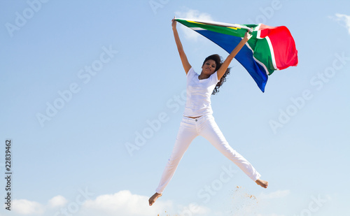 woman jumping holding south african flag