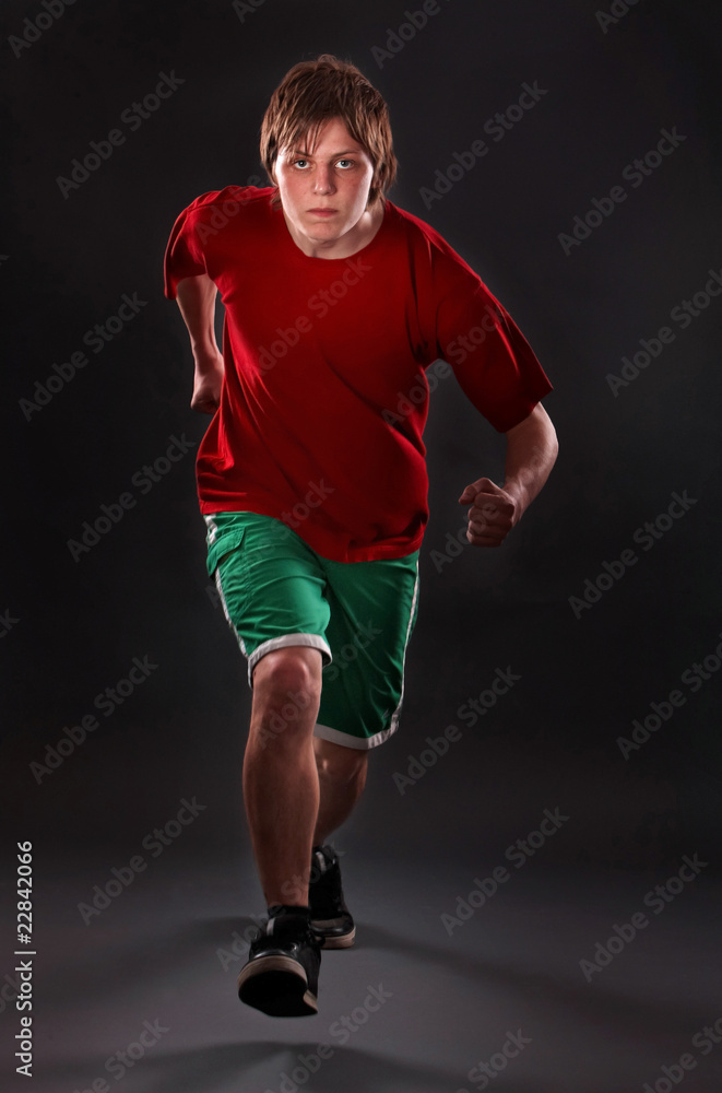 Man running on studio black background.