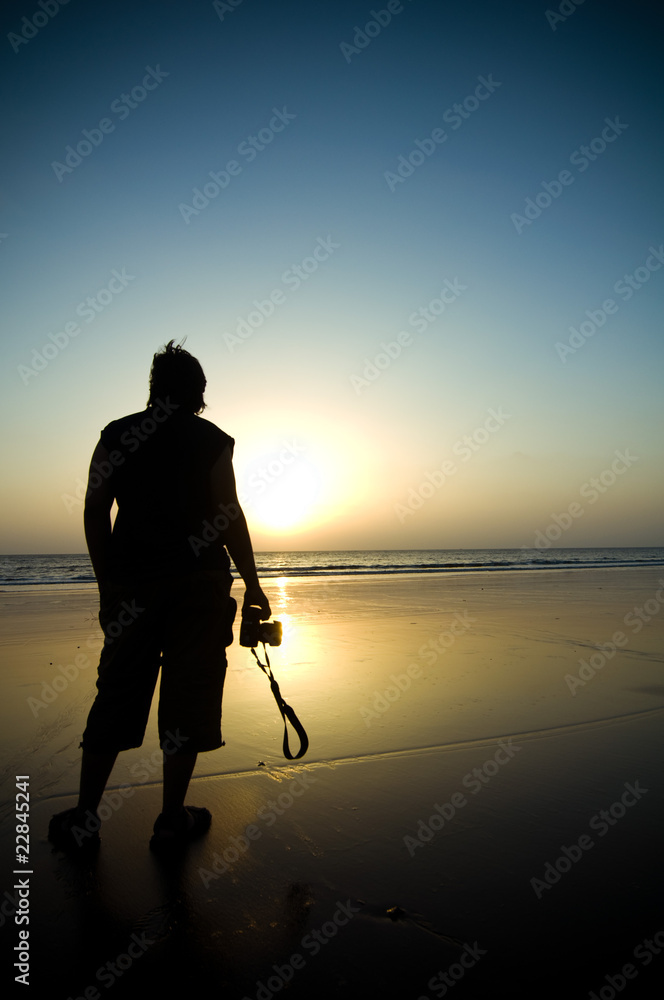 Silhouette of a photographer on a beach during sunset