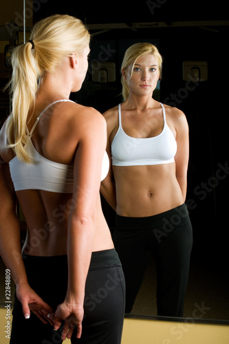 Fit woman standing in front of mirror