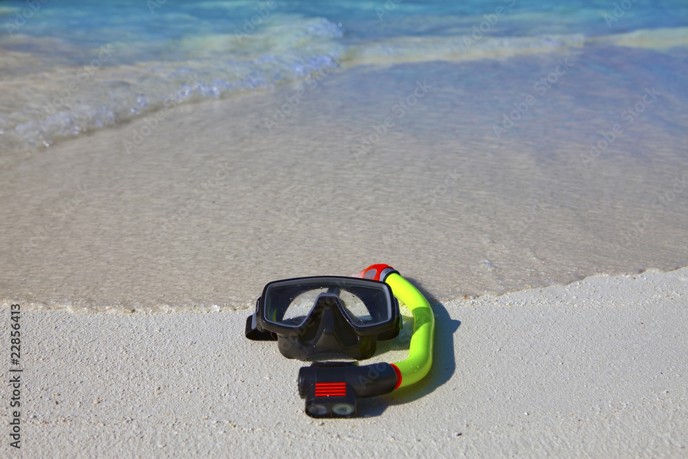 mask and tube lay on sand on background of ocean mask and tube lay on sand on background of ocean