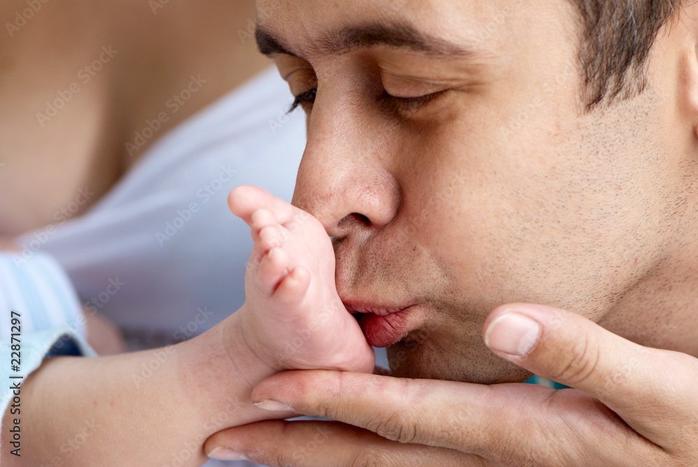 Close up of the father of baby kissing a leg Close up of the father of baby kissing a leg