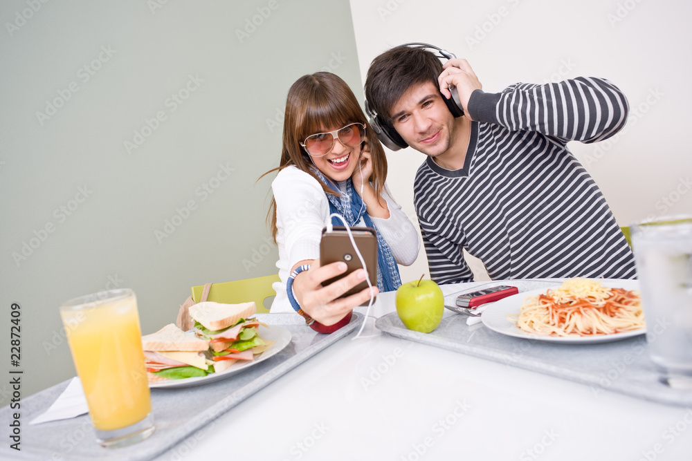 Student cafeteria - teenage couple having fun with music Student cafeteria - teenage couple having fun with music
