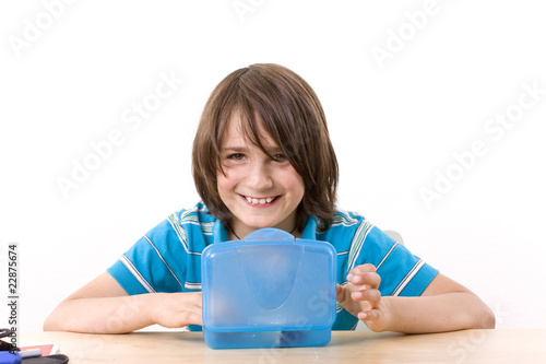 Schuljunge mit Pausenbrot am Schreibtisch