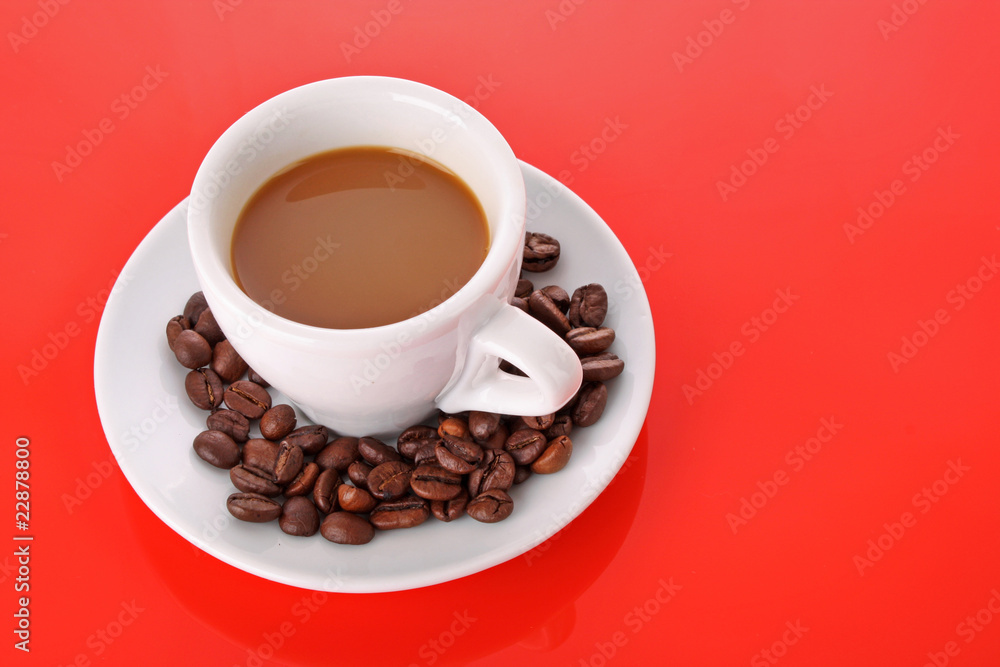Small white cup of coffee with coffee grain on red background Small white cup of coffee with coffee grain on red background