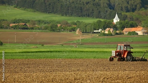 Corn sowing tractor near the village