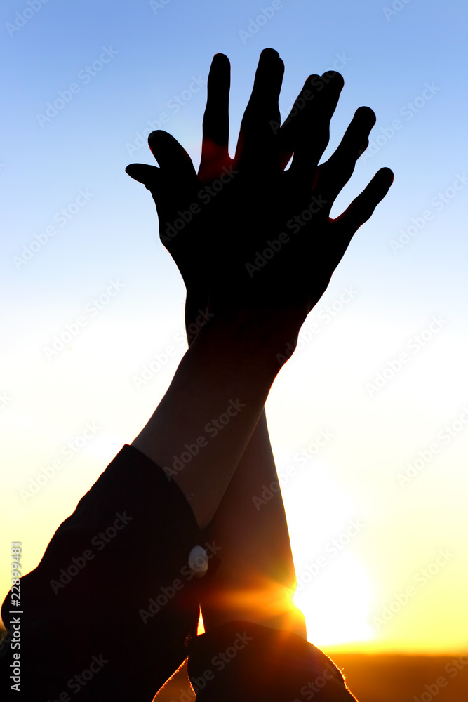 two hands on the sunset background