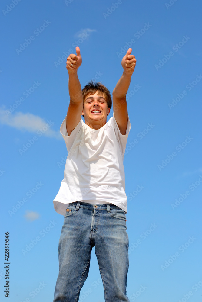 happy teenager jumping on blue sky background happy teenager jumping on blue sky background