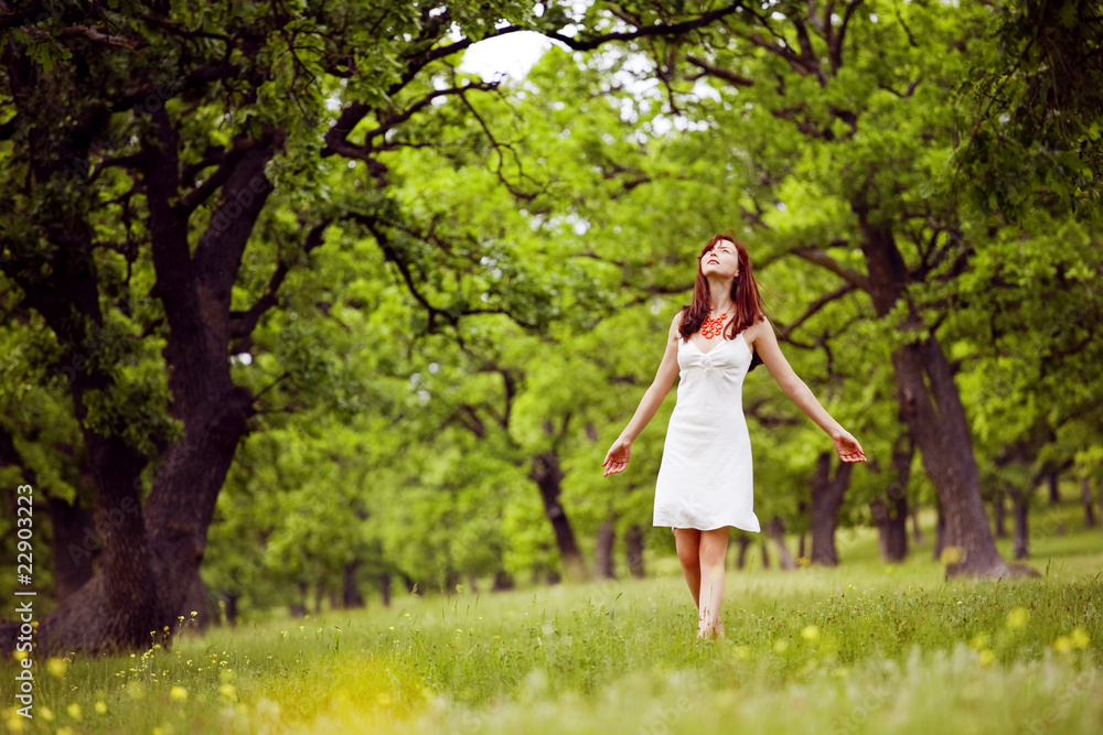 beautiful woman walking through the green forest in summer beautiful woman walking through the green forest in summer