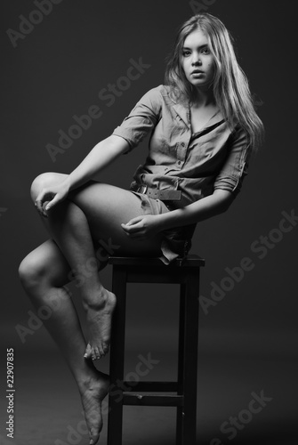 Black and white shot of girl sits on chair