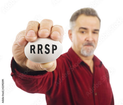 Mature man holds an egg with RRSP on it. photo