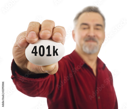 Mature man holds a white nest egg with 401k on it. photo