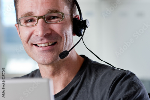 Junger Mann im Callcenter photo