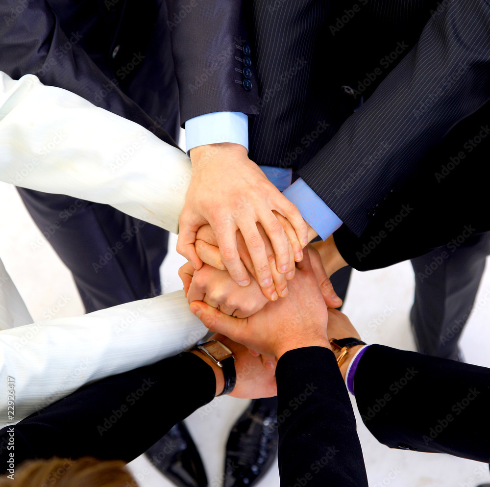group of business people making a pile of hands group of business people making a pile of hands