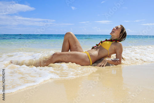teenage girl lying by the water's edge at a hawaii beach © tomas del amo