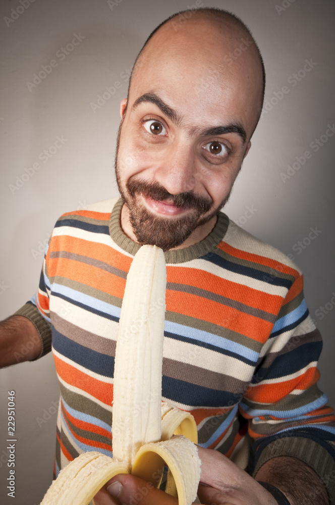 Foto Stock uomo che mangia una banana | Adobe Stock
