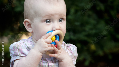 close-up portrait of an adorable toddler sitting on a lawn in a