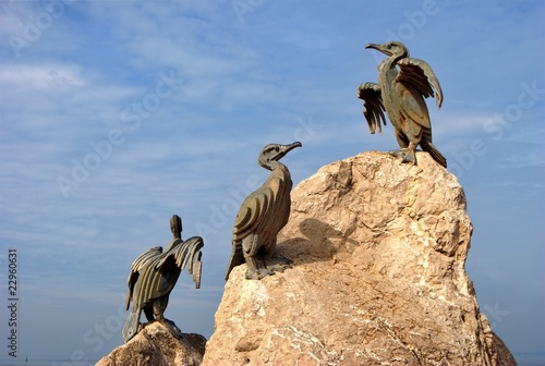 Cormorant sculpture on rock