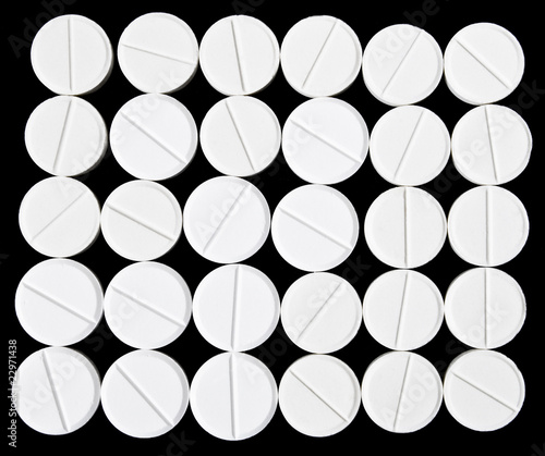 White pills arranged on the black