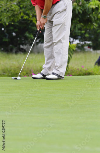 A golfer putting at a golf course