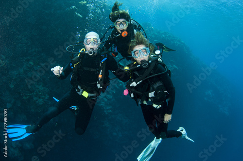 three friends scuba diving together