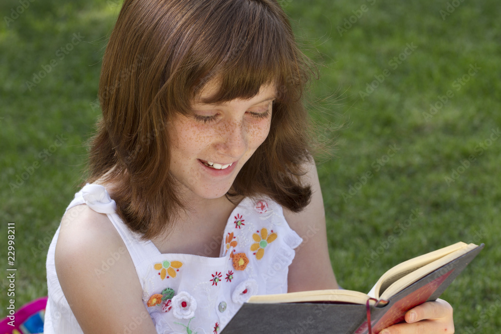 Young beautiful girl reading a book outdoor Young beautiful girl reading a book outdoor