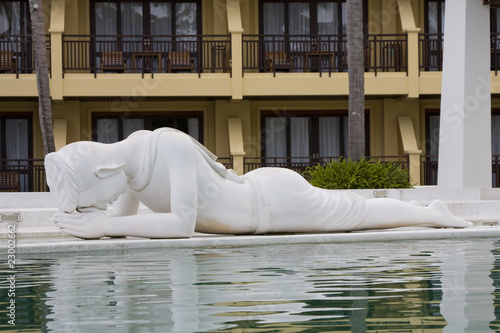The figure of a man lying by the pool. Thailand.