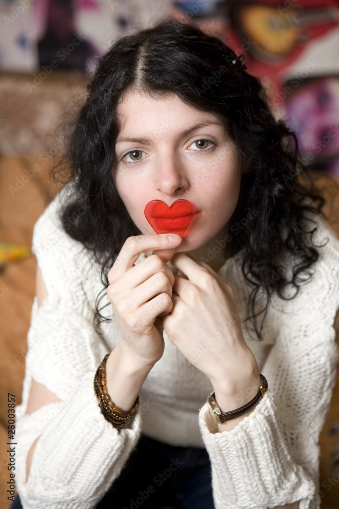 serious young woman with plastic heart nearby lips serious young woman with plastic heart nearby lips