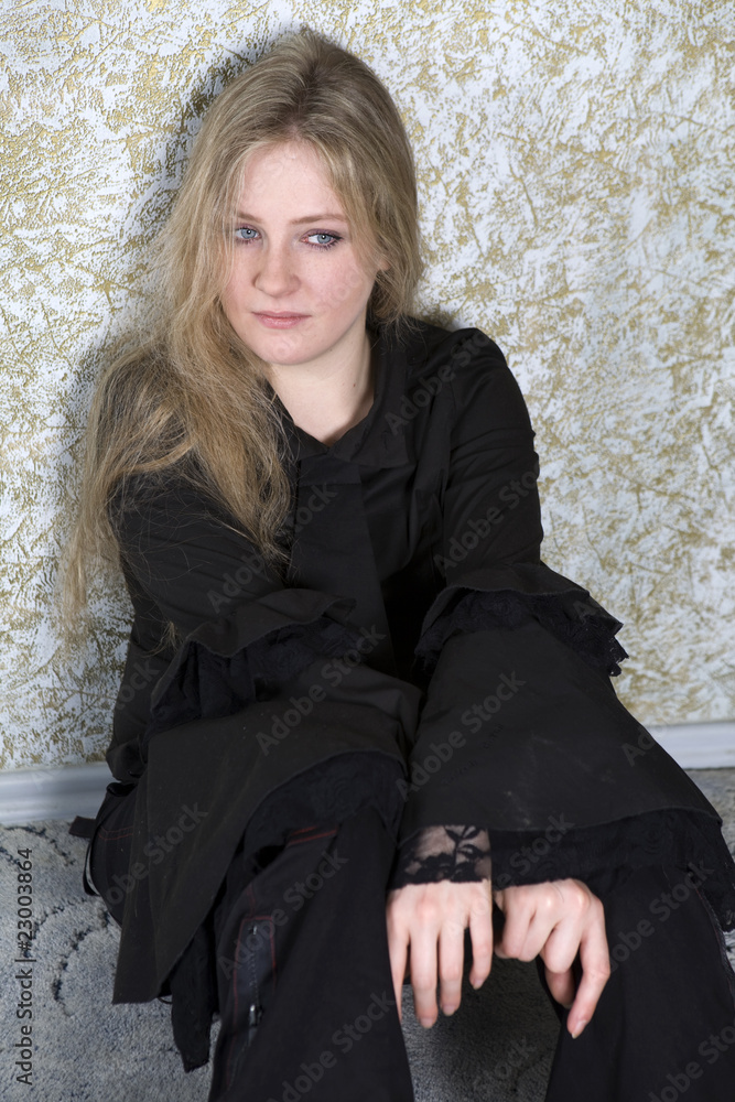 crying teen girl wearing Gothic clothes sitting on the floor crying teen girl wearing Gothic clothes sitting on the floor