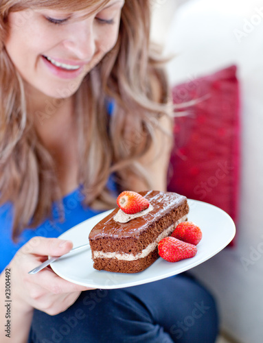 Jolly woman holding a piece of chocolate cake