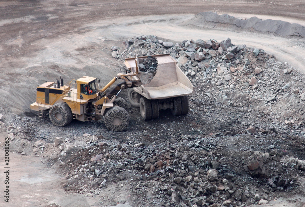 An Excavator Started to Load a Lorry in a Granite Quarry. An Excavator Started to Load a Lorry in a Granite Quarry.