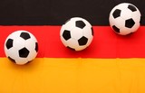 three soccer balls on German flag