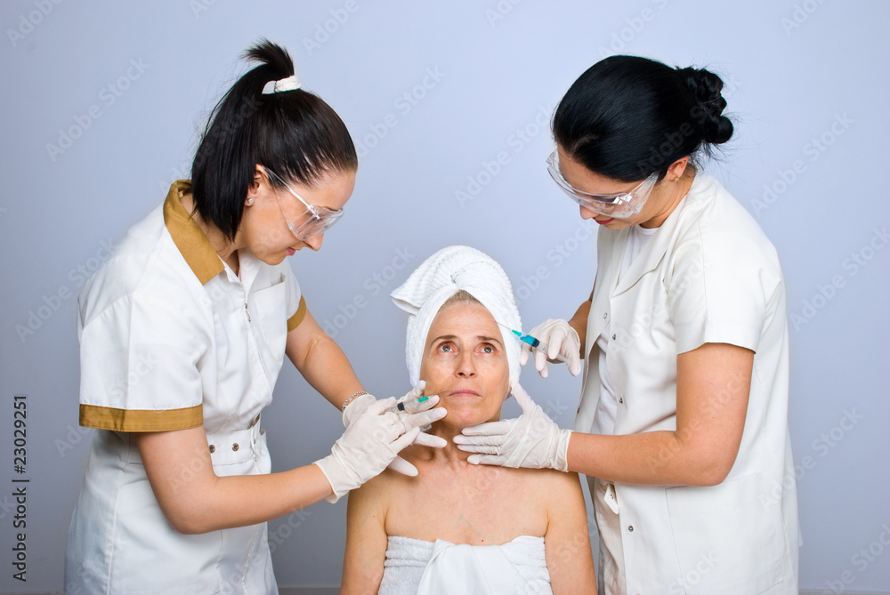 Doctors injecting botox to senior woman Doctors injecting botox to senior woman