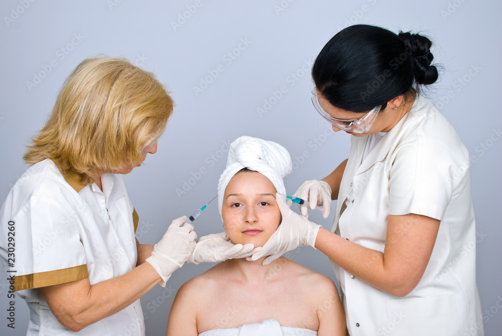 Plastic surgeons injecting botox to a woman Plastic surgeons injecting botox to a woman