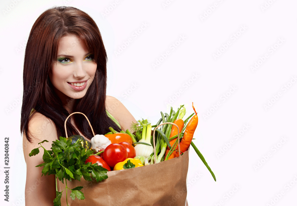 Woman with a shopping bag filled with nutritious fruit and veget Woman with a shopping bag filled with nutritious fruit and veget