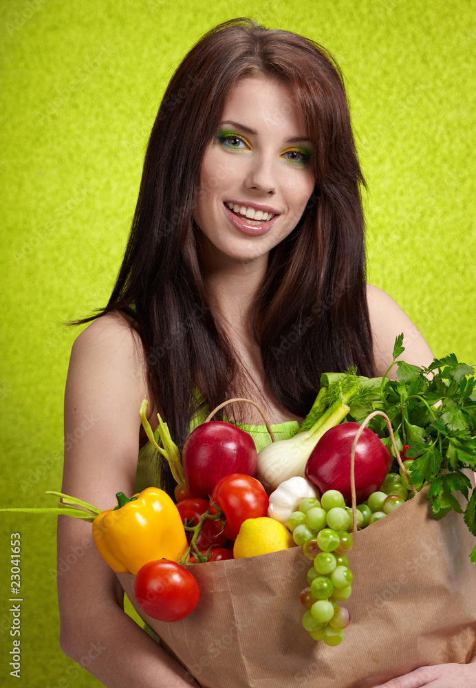 Woman with a shopping bag filled with nutritious fruit and veget Woman with a shopping bag filled with nutritious fruit and veget