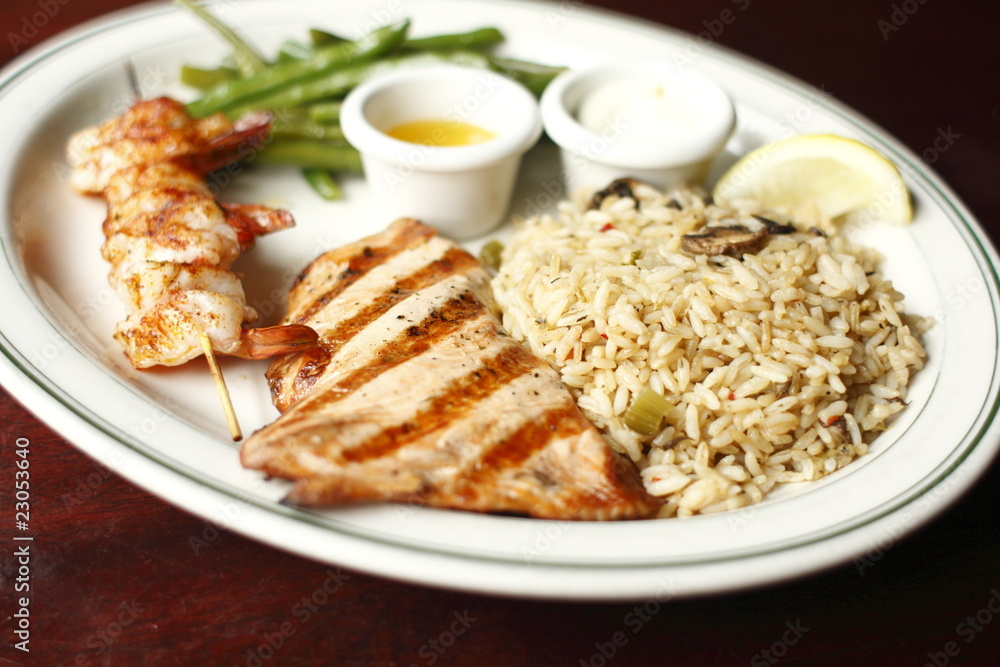 A plate of grilled salmon and prawns. A plate of grilled salmon and prawns.