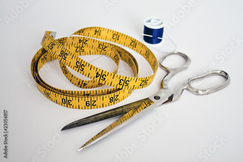 Tailor's tools: needle,thread,measuring tape, and scissors