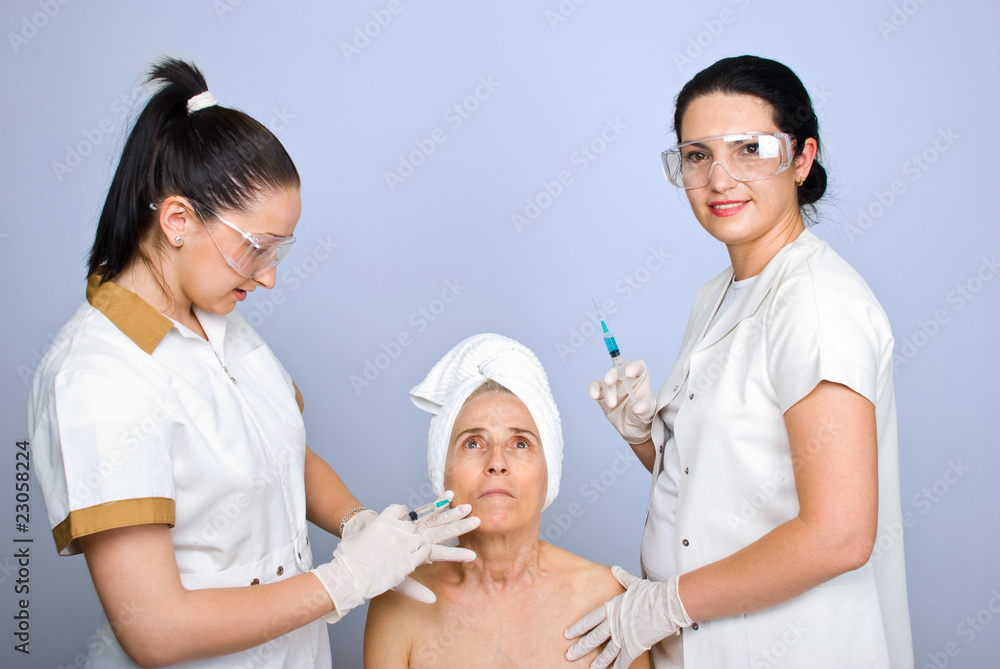 Doctor inject botox to senior cheek woman